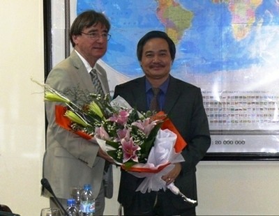 PGS.TS. Phùng Xuân Nhạ thay mặt lãnh đạo Trường Đại học Kinh tế - ĐHQGHN tặng hoa cảm ơn GS. Tom Cannon.